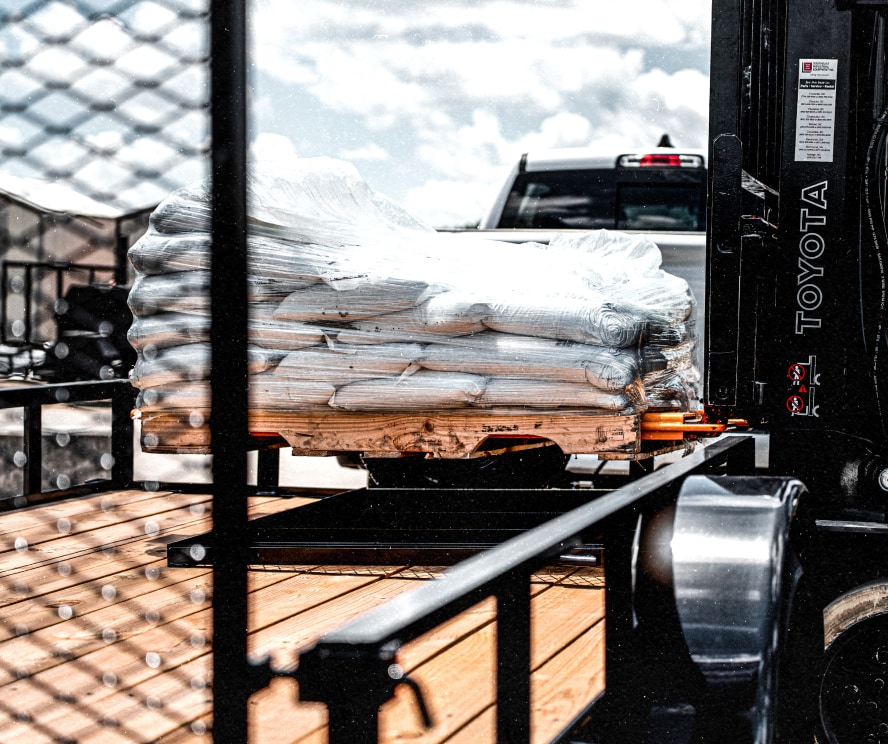 Pallets of soil being loaded on to a trailer.